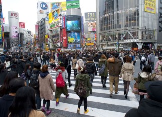 Urban bustle, people crossing a busy cross walk in Shibuya, Tokyo, Japan