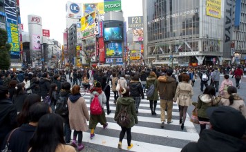 Urban bustle, people crossing a busy cross walk in Shibuya, Tokyo, Japan