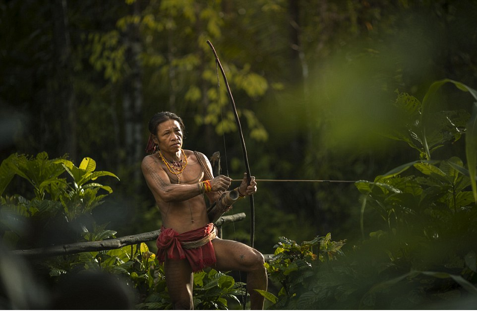 One member of the Mentawai tribe uses a large handmade bow and arrow to hunt and forage for food