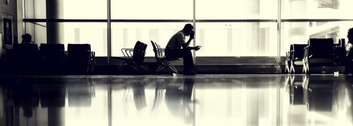man-sitting-at-airport-hero-airport airline travel tips