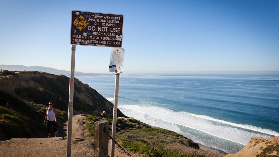 Warning sign in front of the cliffs at Black's Beach.