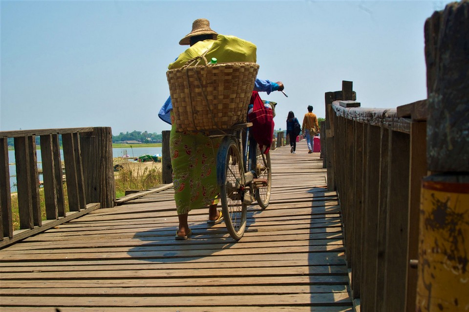 Locals walk across U Bein Bridge in Mandalay